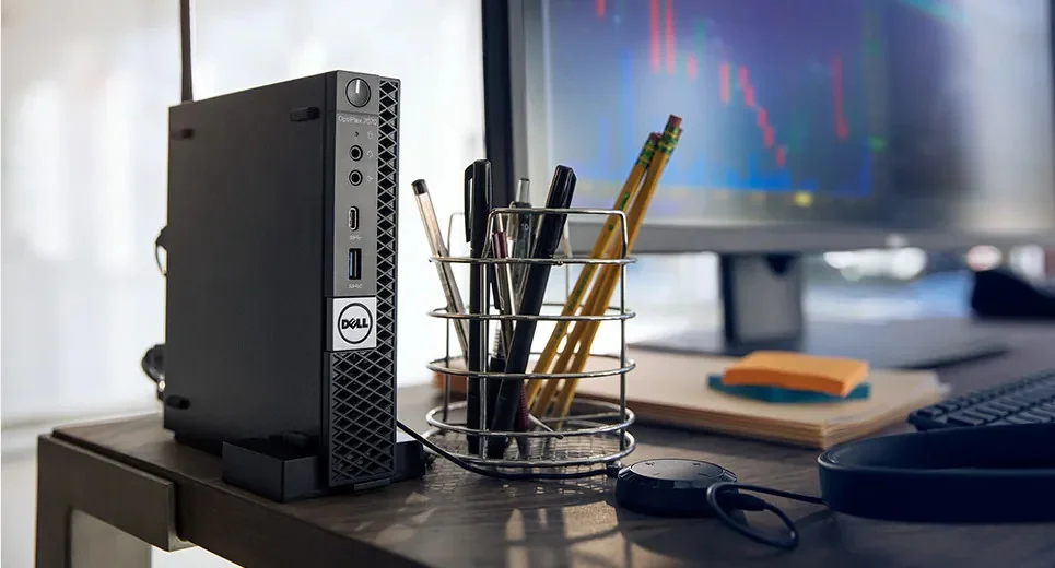 A Dell OptiPlex 7070 Micro standing upright on a desk, next to a pencil holder and a monitor